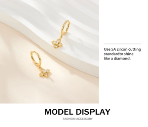 Close-up of gold S925 silver clover earrings with 5A zircons on a white display