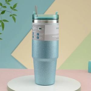 Close-up of 30oz blue glitter stainless steel vacuum tumbler on a display stand