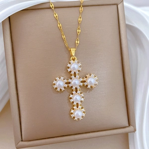 Macro view of a gold cross pendant necklace with pearls and sparkling zircons