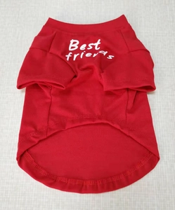 Flat lay of a red cotton dog T-shirt with white Best Friends text on a textured surface