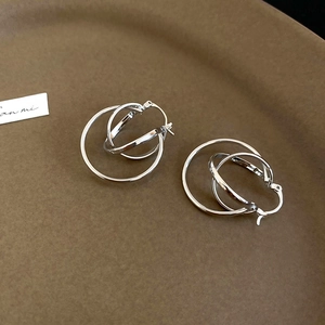 Macro shot of silver layered circular earrings with polished metallic intertwined design