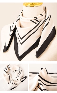 Detail of white and black striped silk scarf showing the elegant knot and smooth texture
