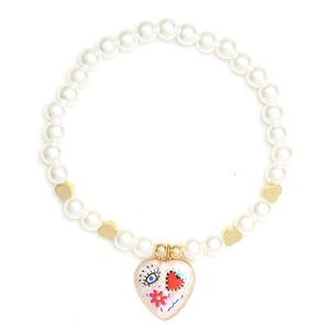 Macro detail of pearl bracelet with golden heart beads and painted heart eye pendant