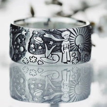 Macro shot of vintage silver ring featuring engraved Little Prince and fox motifs