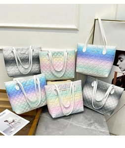 Detailed display of assorted gradient quilted tote bags with elegant gold logos
