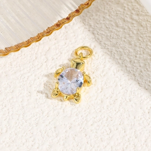 Macro view of gold turtle pendant with an oval faceted gemstone for jewelry making