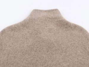 Dettaglio del collo alto in maglia color avena con trama fine in lana cashmere