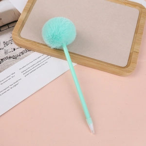 Close-up of a mint green plush pom pom ball pen on a pink desk with ins-style props