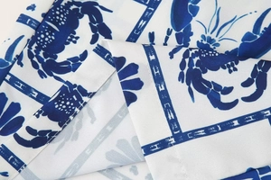 Detailed close-up of textile fabric featuring blue crab print and geometric patterns