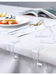 Close-up of transparent acrylic tablecloth clips in L-shape and triangle for table grip
