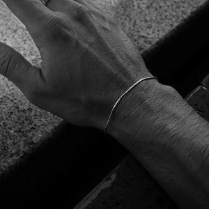 Gros plan sur un bracelet minimaliste en titane argenté au poignet avec détails nets