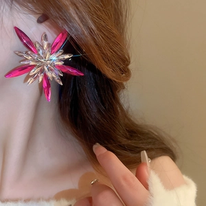 Luxury oversized starburst earrings with rose red crystals and shimmering star effect