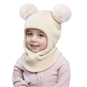 Detail of warm beige knit baby balaclava hat with two large faux fur pom-poms