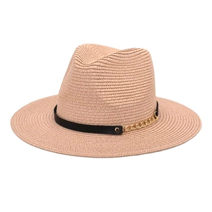 Detailed close-up of beige woven fedora featuring a black leather band with gold chain and studs