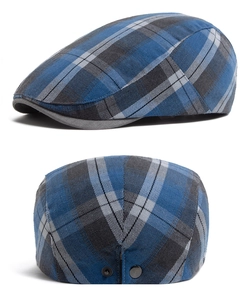 Detail of classic plaid ivy cap featuring metal side buckles and textured cotton fabric