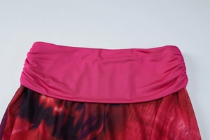 Détail de la taille plissée fuchsia avec un tissu imprimé tie-dye rouge et noir