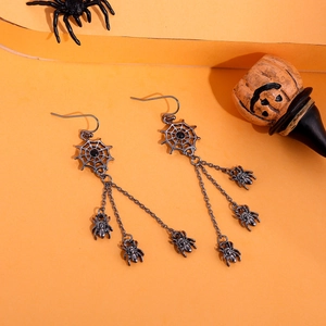 Gothic punk black spider web dangle earrings with tassels on a festive orange background