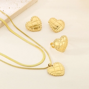Detailed close-up of 18K gold-plated heart jewelry set with classic quilted texture