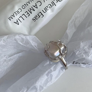 Macro view of 925 silver ring featuring a baroque square pearl on a lava texture band
