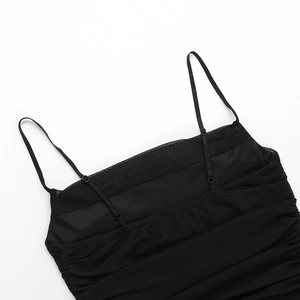 Detailed close-up of adjustable thin straps and black mesh ruffles on a bodycon dress