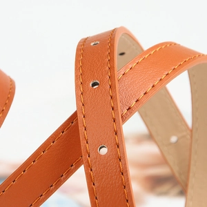 Brown faux leather thin waist belt with double yellow stitching and metal eyelets