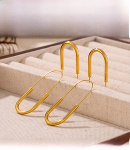 Detail of PVD electroplated gold paperclip earrings with a mirror-like high-light finish
