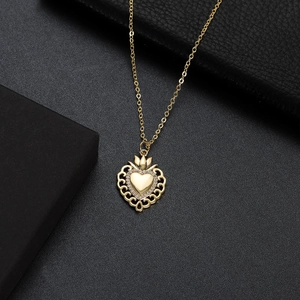 Detail of gold heart pendant with crown design and zircon stone in a black gift box