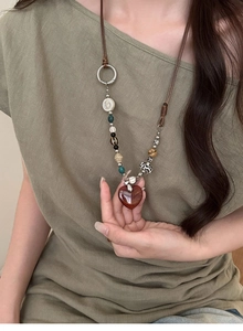Close-up of bohemian heart pendant necklace with retro stone beads on leather cord