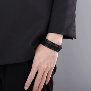 Detail of multilayer black braided leather bracelet on wrist with elegant texture