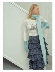 Detailed texture of soft mint green wool blend knitted scarf and matching gloves for winter