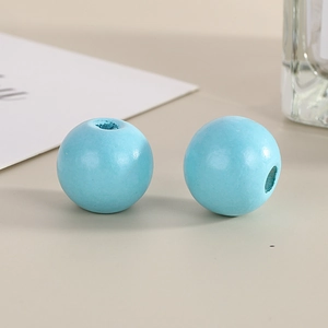 Macro shot of 16mm light blue painted wooden beads with threading holes for jewelry making