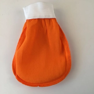 Detailed texture of orange exfoliating Moroccan bath mitt with white elastic cuff