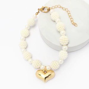 Close-up of pearl pet necklace with gold heart pendant and adjustable lobster clasp