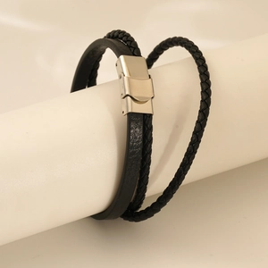 Detail of men's leather bracelet with braided texture and silver magnetic steel clasp