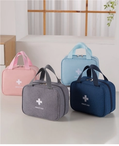 Four colorful portable first aid bags in pink, grey, and blue with zipper and handles