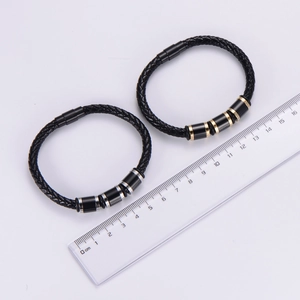 Detail view of woven leather bracelets with magnetic clasps and a measuring ruler