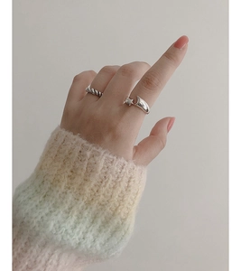 Detailed view of silver star and moon open ring with twisted rope texture on finger