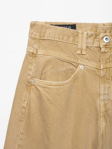 Detailansicht von Taille, Metallknopf und Tasche dieser khakifarbenen Wide-Leg-Jeans