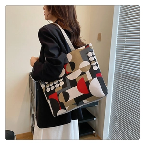 Canvas tote bag with geometric print shown on model in a modern minimalist setting