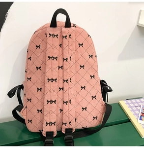 Rear view of pink corduroy backpack with bow pattern and adjustable nylon straps