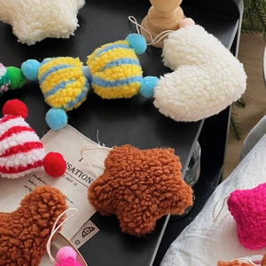 Detailed view of plush lamb wool Christmas charms in star, heart and bow shapes