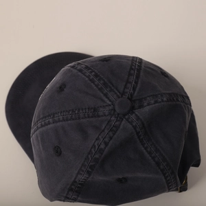 Detail of high-quality navy blue cotton baseball cap with curved brim and metal buckle