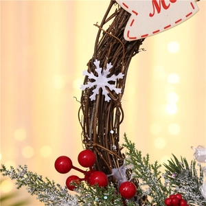 Detail of Christmas wreath featuring dried vines, red berries, pine needles and snowflake