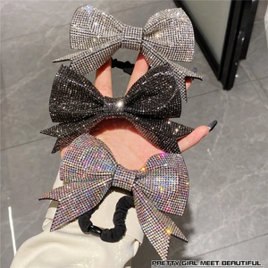 Close-up of sparkling rhinestone bow hair ties in silver, black and iridescent colors