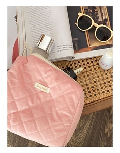 Vue détaillée de la trousse de maquillage rose matelassée avec fermeture éclair en métal