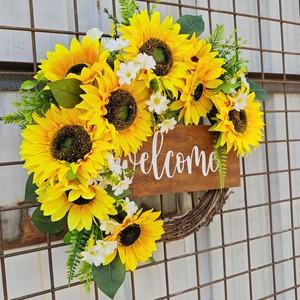 Détail de la couronne de bienvenue avec tournesols jaunes et feuilles sur rotin