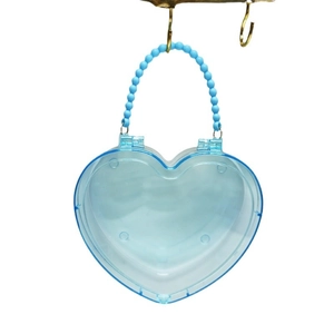Custodia per gioielli a cuore trasparente con manico di perle azzurre su sfondo bianco