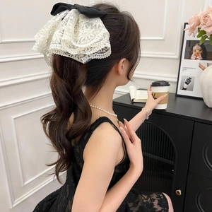 Close-up of elegant lace bow hair claw clip worn by a model in a sophisticated setting
