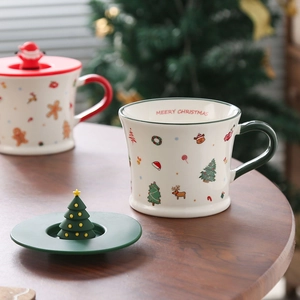 Detail of a Christmas ceramic mug with a green lid and a miniature tree decoration