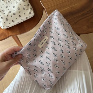 Detailed close-up of floral cotton pouch with simple wish label and soft fabric texture